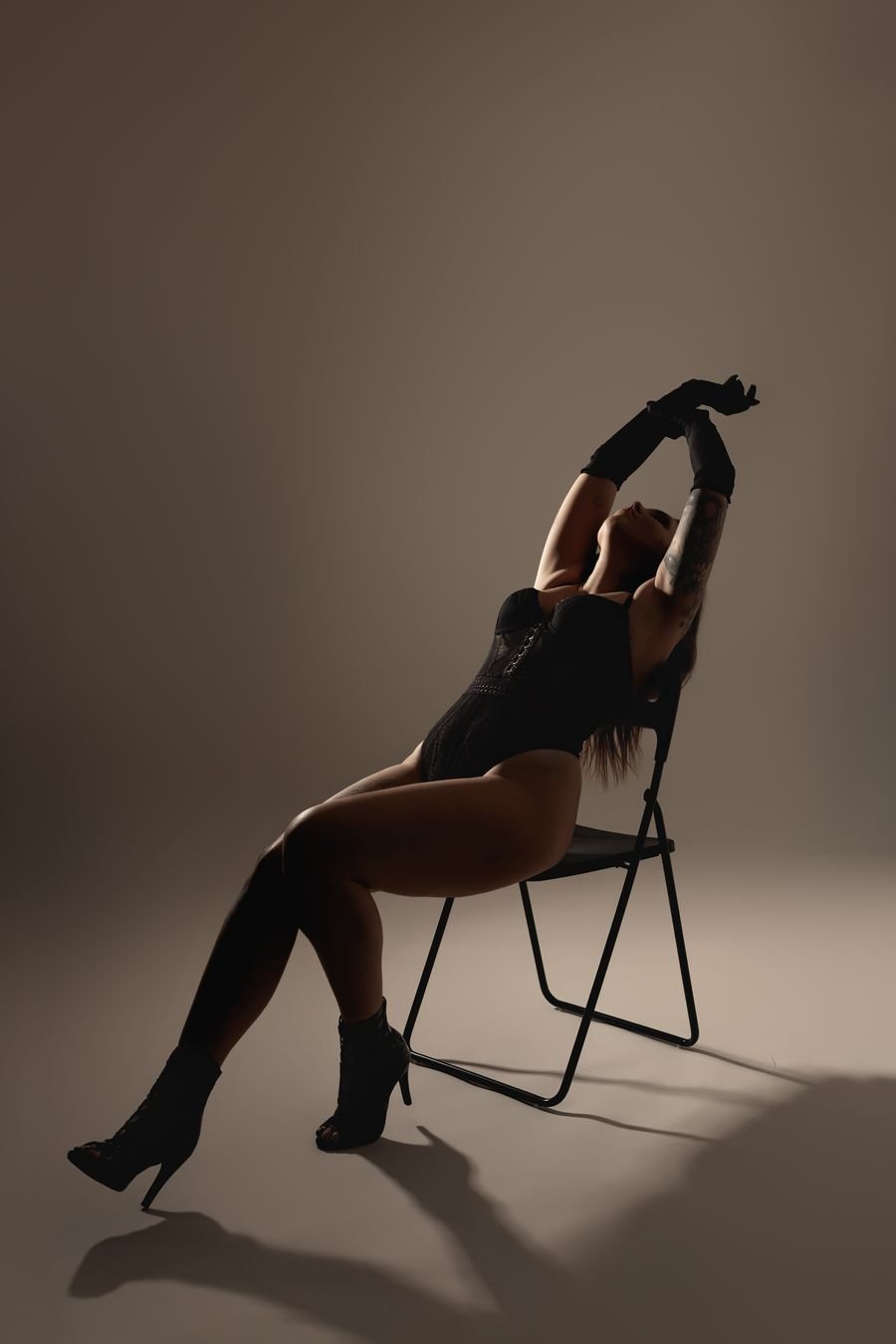 Pose sur chaise, bras levés, lumière latérale